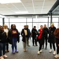 speaker gives directions to group of students who form semicircle in room